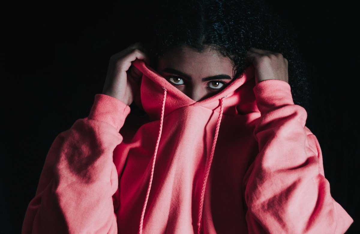 woman hiding behind hoodie